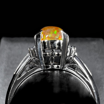 A platinum filigree and diamond-accented Mexican fire opal ring.  The opal is orange with green fire.