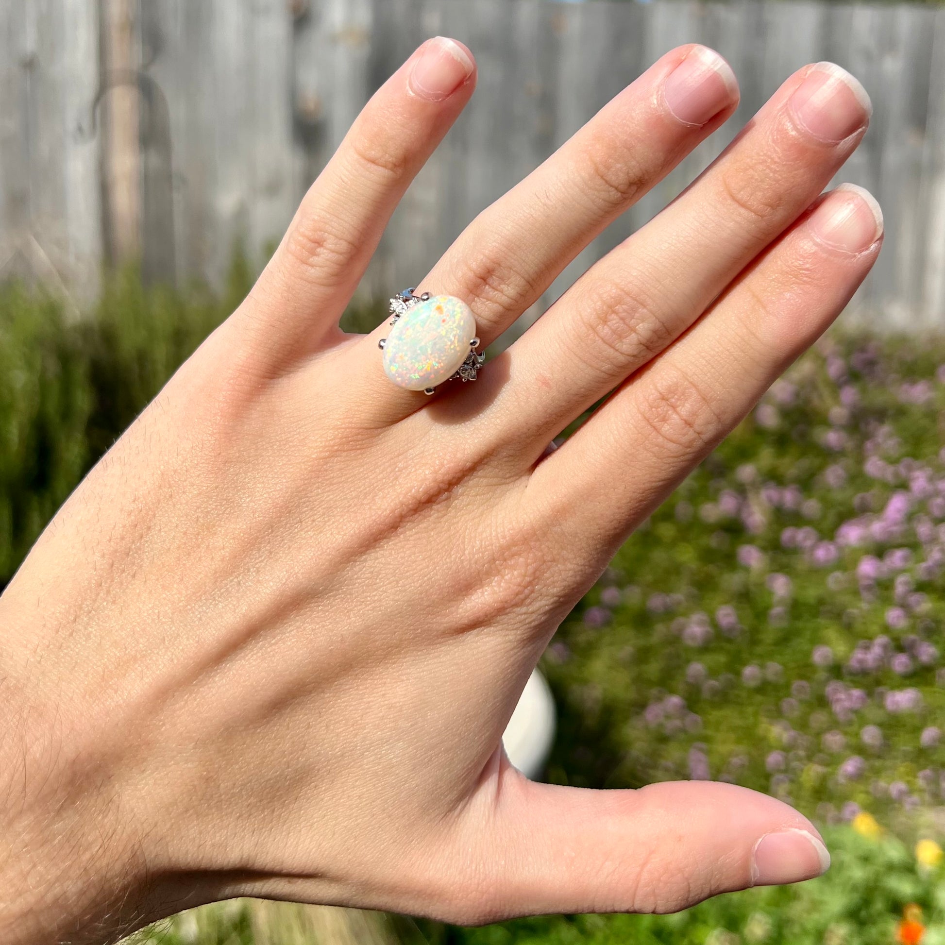 A platinum statement ring mounted with a 7.97ct Coober Pedy opal and marquise cut diamond accents.