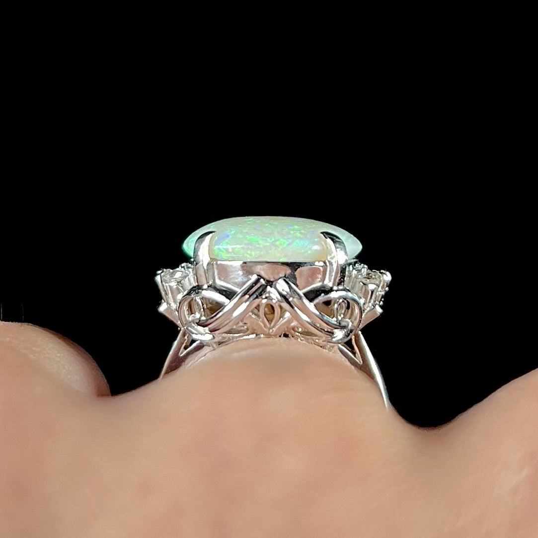 A round cut Australian opal and diamond engagment ring with platinum filigree.