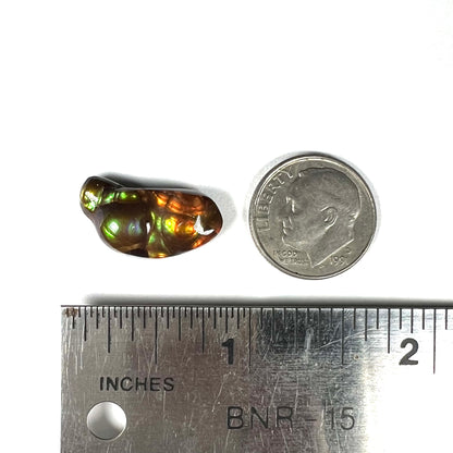 A loose, freeform shaped fire agate stone.  The fire agate has red, orange, and yellow colors on one side, and the other has green and blue colors.