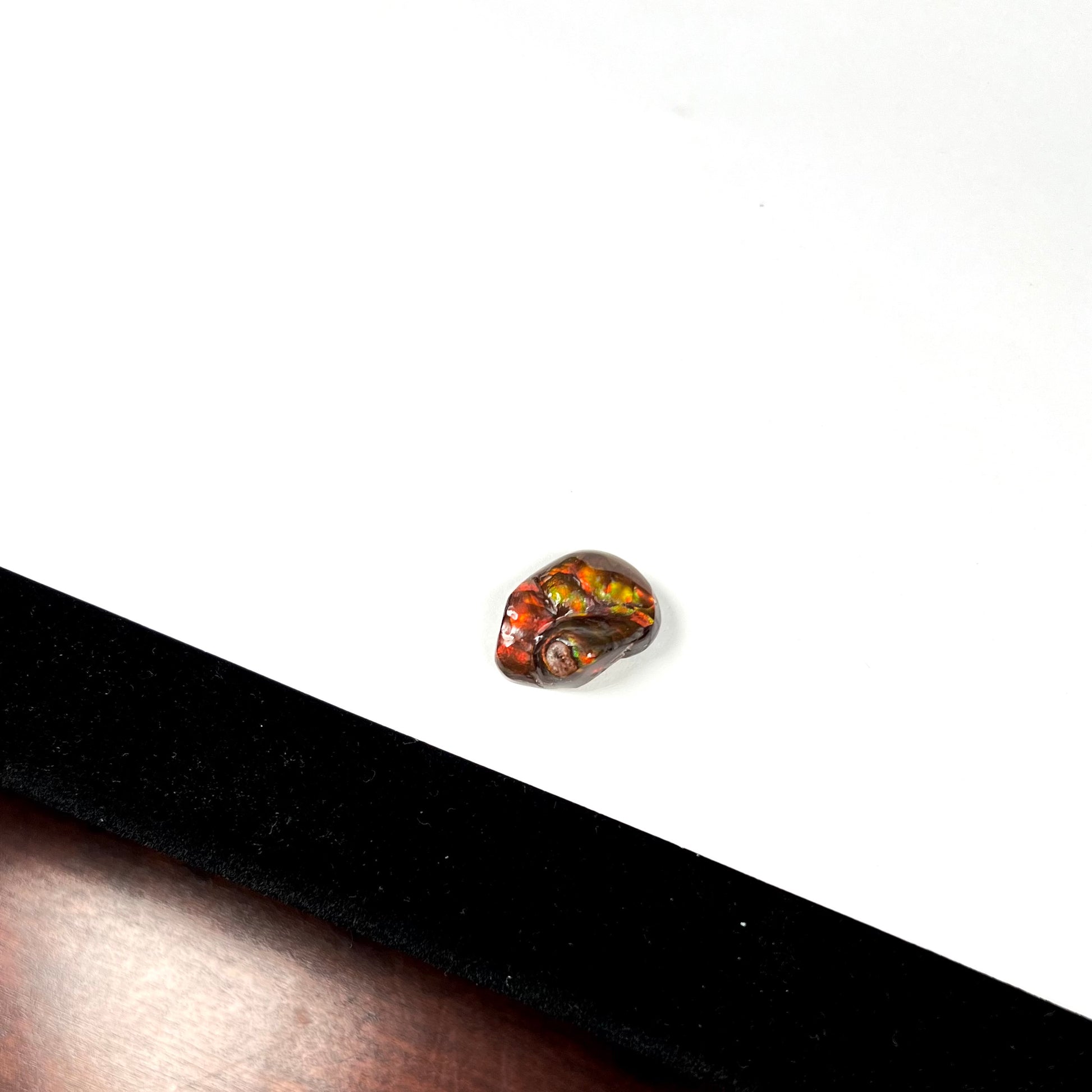 A large Mexican fire agate gemstone.  The stone is red with green iridescence and a waxy luster.