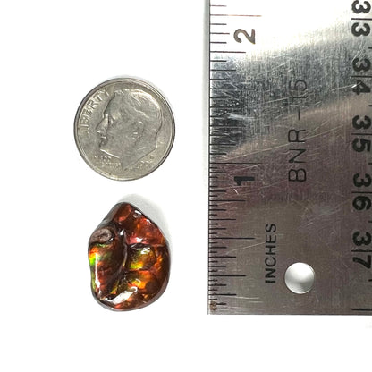 A large Mexican fire agate gemstone.  The stone is red with green iridescence and a waxy luster.