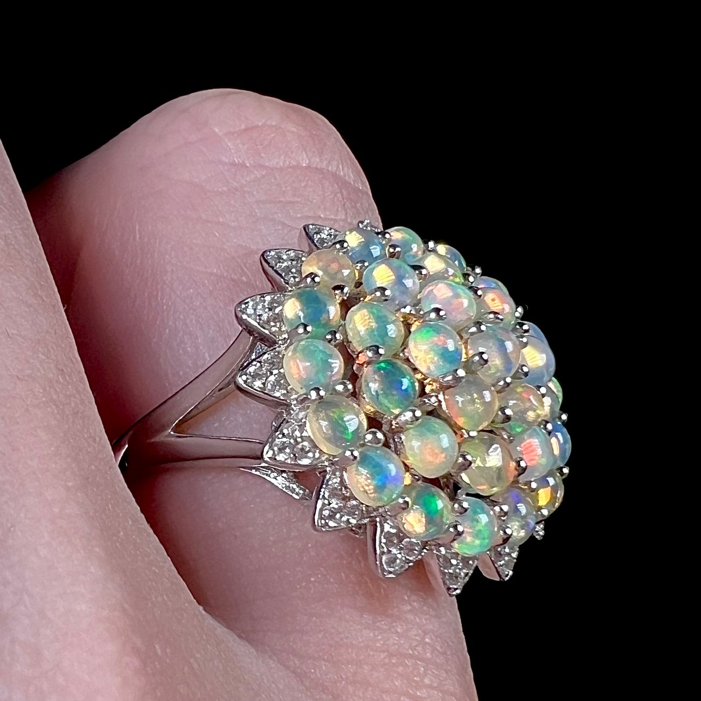 A sterling silver cluster flower ring mounted with 33 round Ethiopian fire opals.