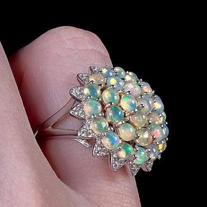 A sterling silver cluster flower ring mounted with 33 round Ethiopian fire opals.