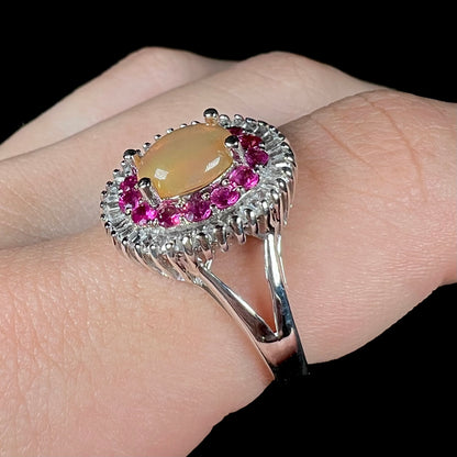 A sterling silver Ethiopian opal ring mounted with a halo of white CZs and another halo of synthetic pink sapphires.