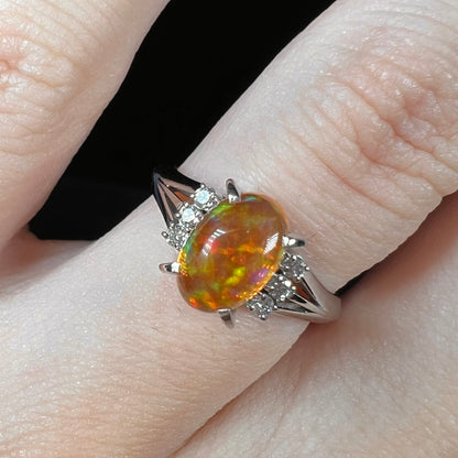 A platinum filigree and diamond-accented Mexican fire opal ring.  The opal is orange with green fire.