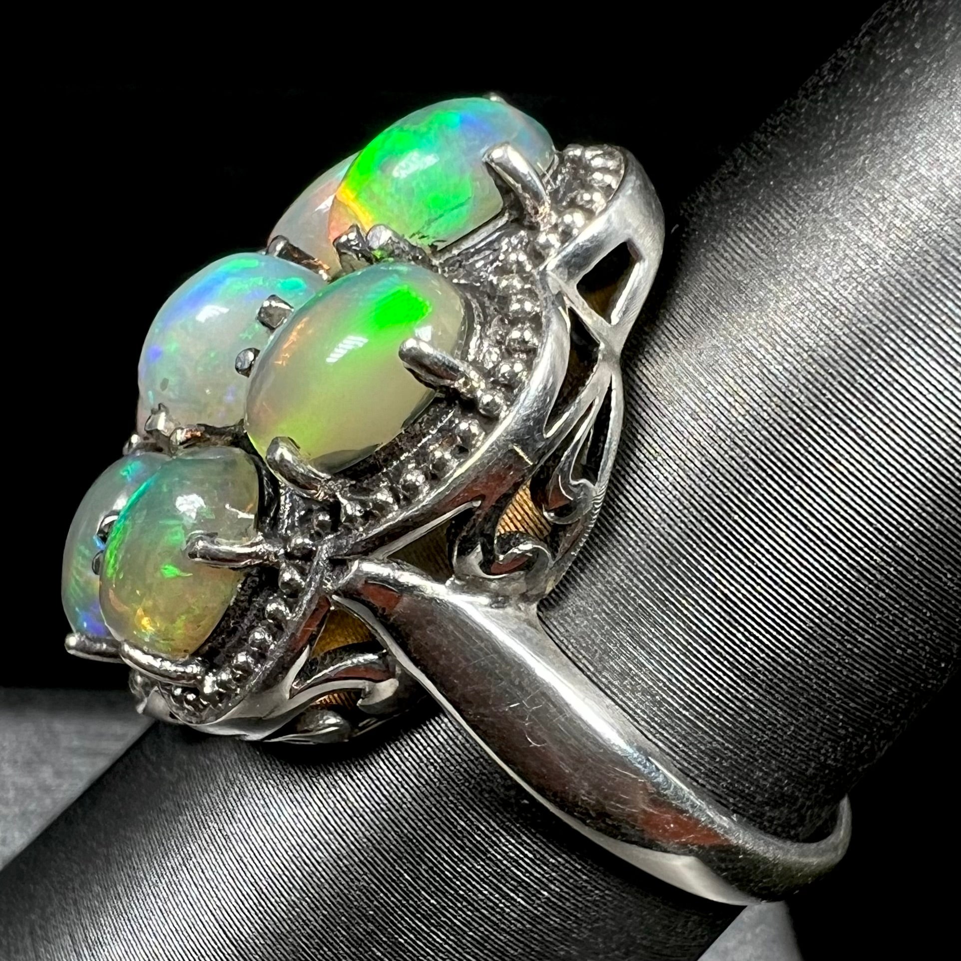 A sterling silver cluster ring prong-set with seven green Ethiopian fire opals.