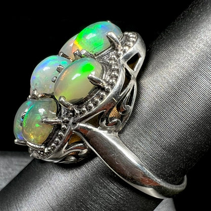 A sterling silver cluster ring prong-set with seven green Ethiopian fire opals.