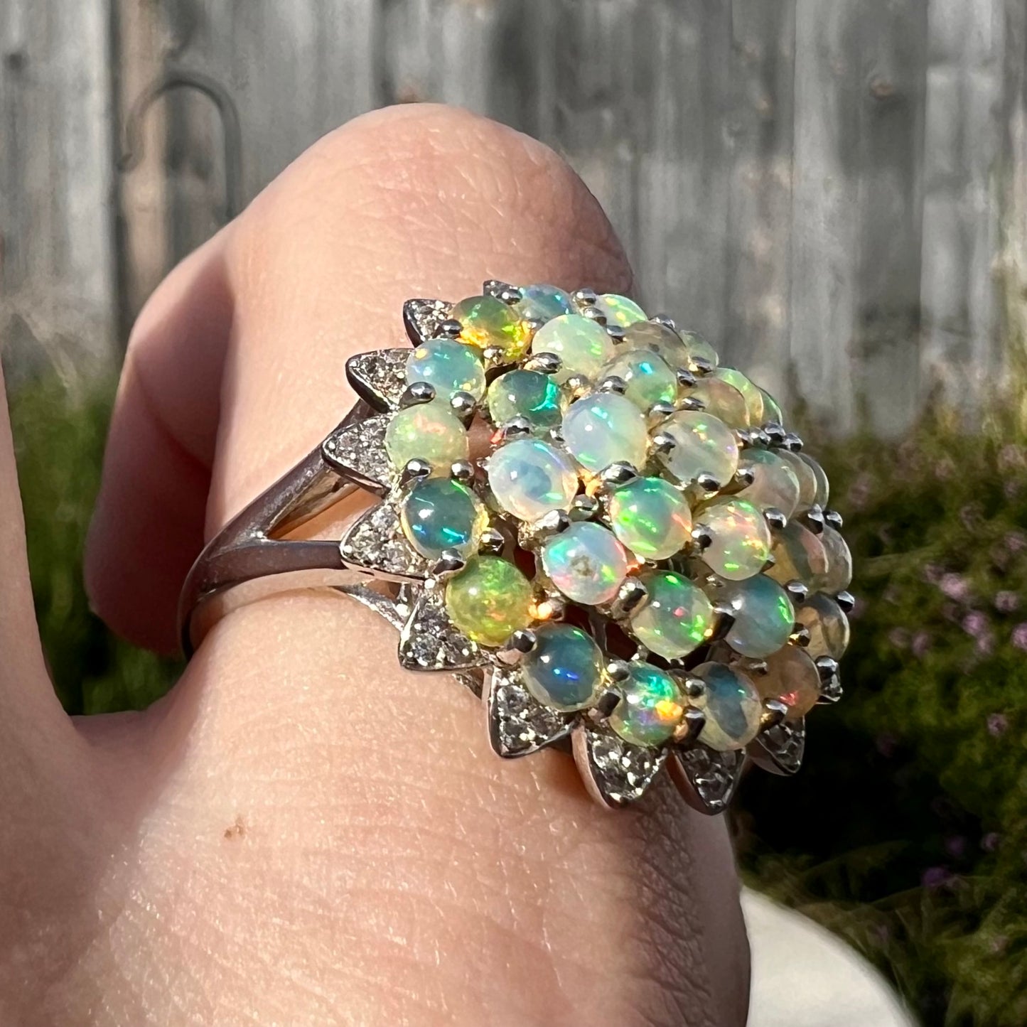 A sterling silver cluster flower ring mounted with 33 round Ethiopian fire opals.