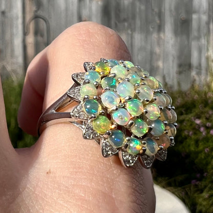 A sterling silver cluster flower ring mounted with 33 round Ethiopian fire opals.