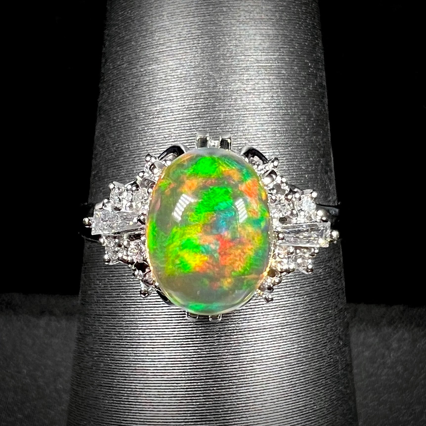 A platinum filigree ring mounted with a high-domed Mexican fire opal and baguette cut diamond accents.