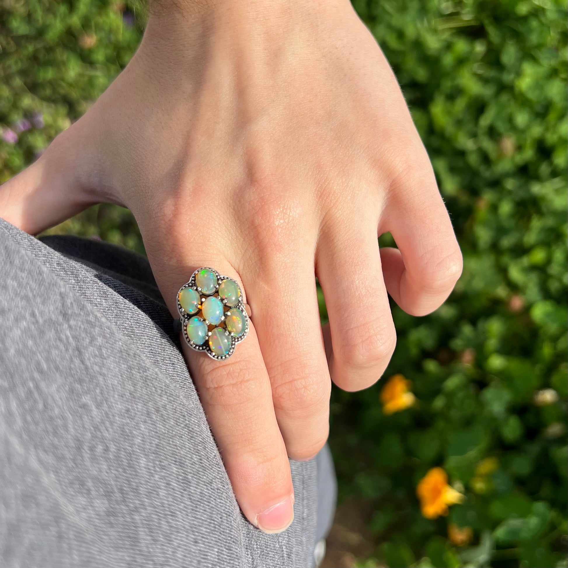 A sterling silver cluster ring prong-set with seven green Ethiopian fire opals.