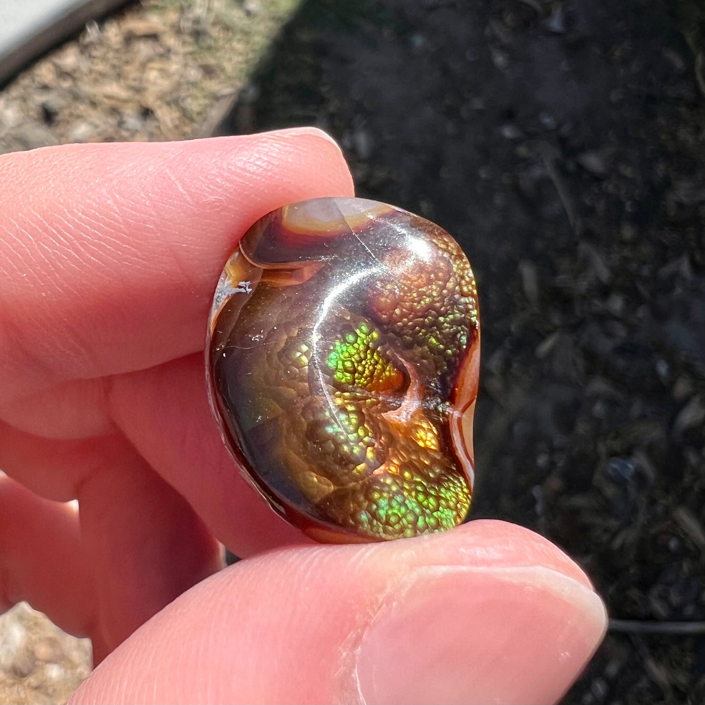 A large Mexican fire agate cabochon.  The stone has a bubbly green pattern.