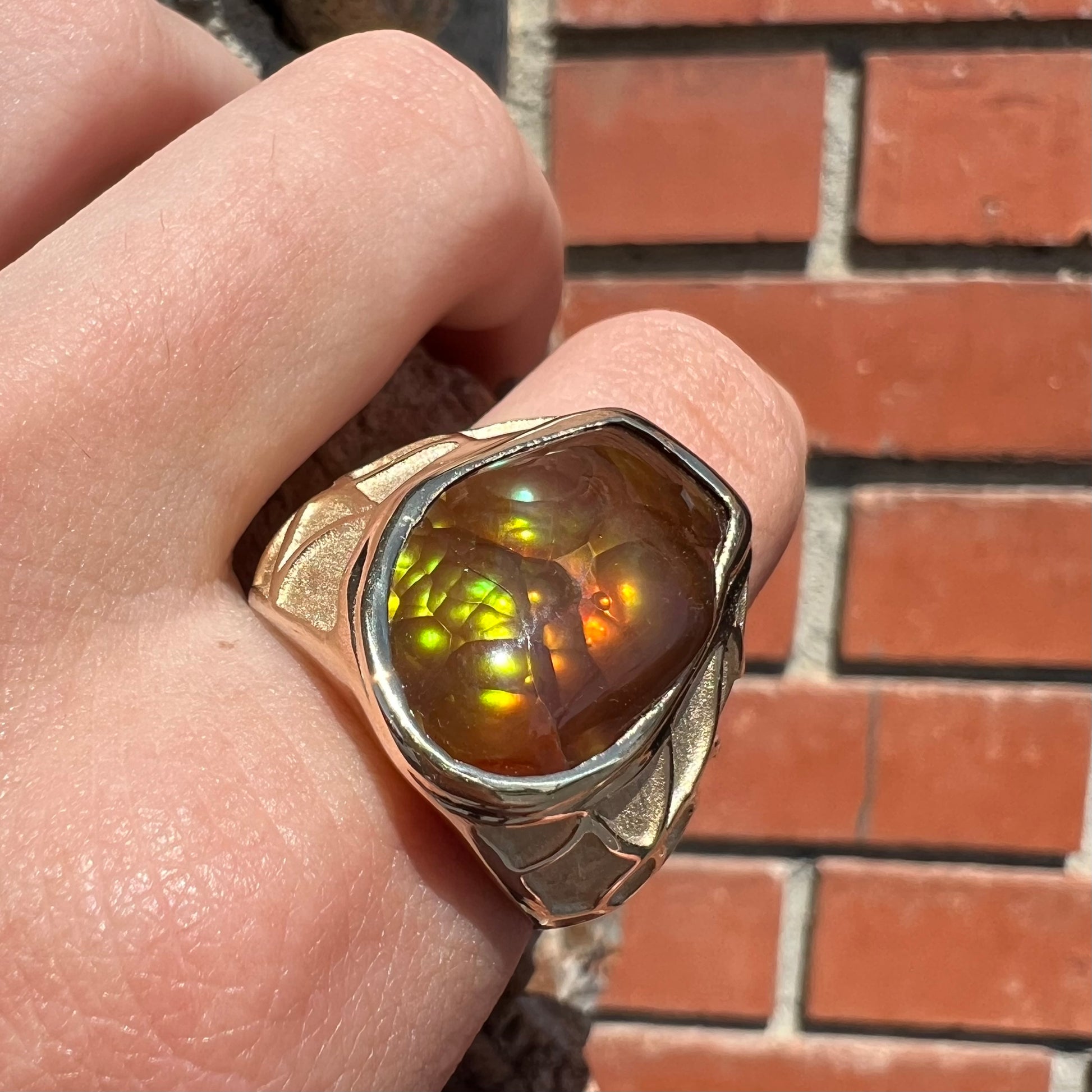 A men's heavy yellow gold ring mounted with a Mexican fire agate stone.  The shank of the ring is textured.