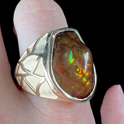 A men's heavy yellow gold ring mounted with a Mexican fire agate stone.  The shank of the ring is textured.