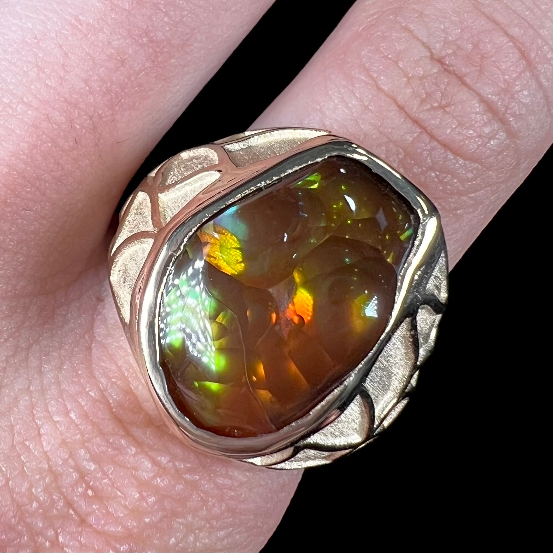 A men's heavy yellow gold ring mounted with a Mexican fire agate stone.  The shank of the ring is textured.