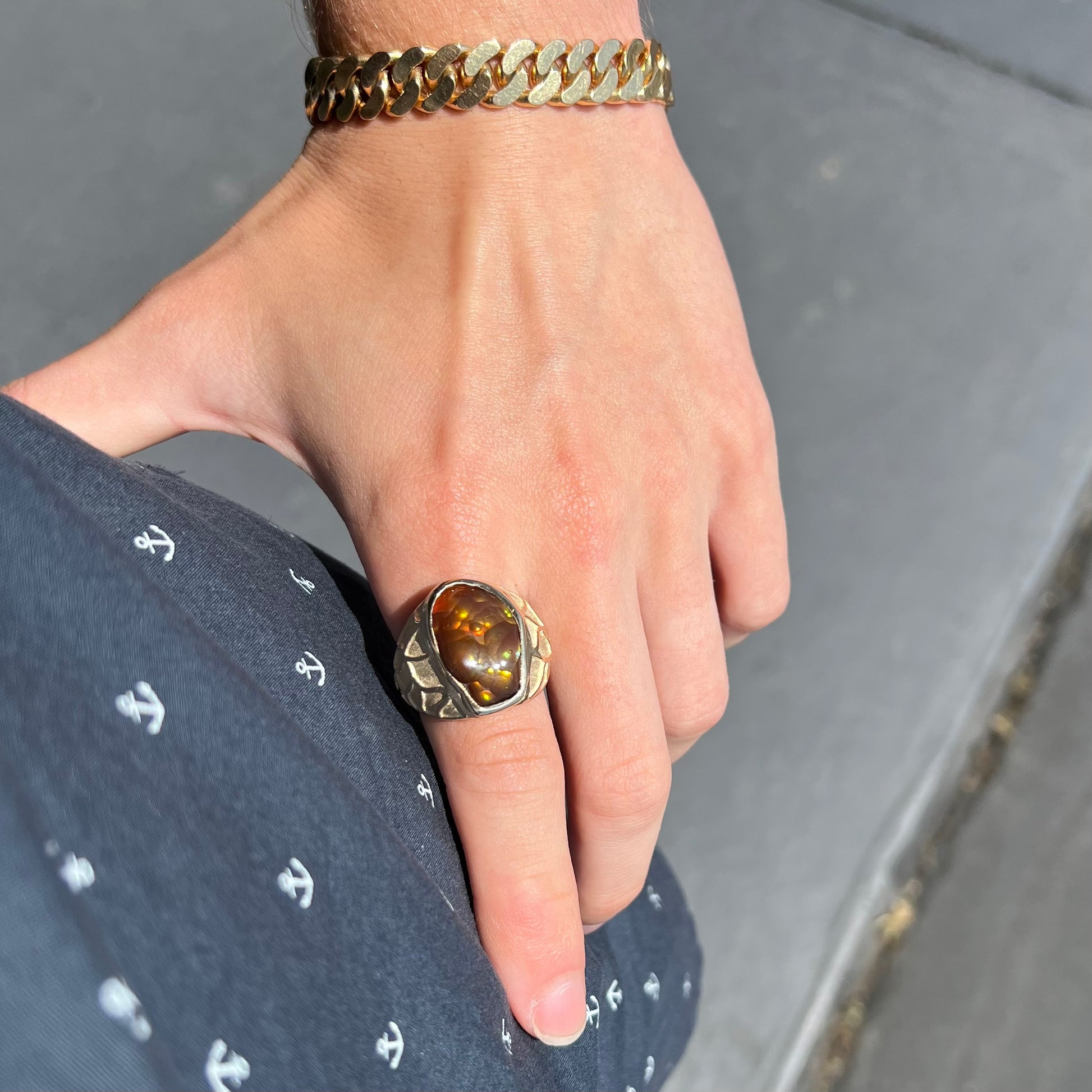 A men's heavy yellow gold ring mounted with a Mexican fire agate stone.  The shank of the ring is textured.