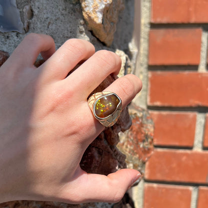 A men's heavy yellow gold ring mounted with a Mexican fire agate stone.  The shank of the ring is textured.