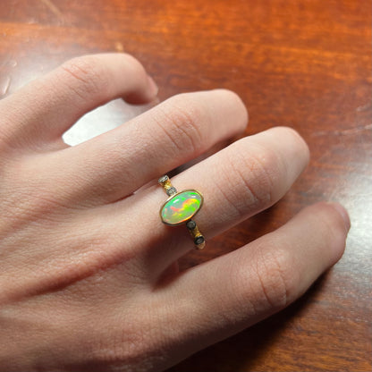 A yellow gold plated sterling silver ring mounted with an Ethiopian fire opal and rose cut diamond accents.