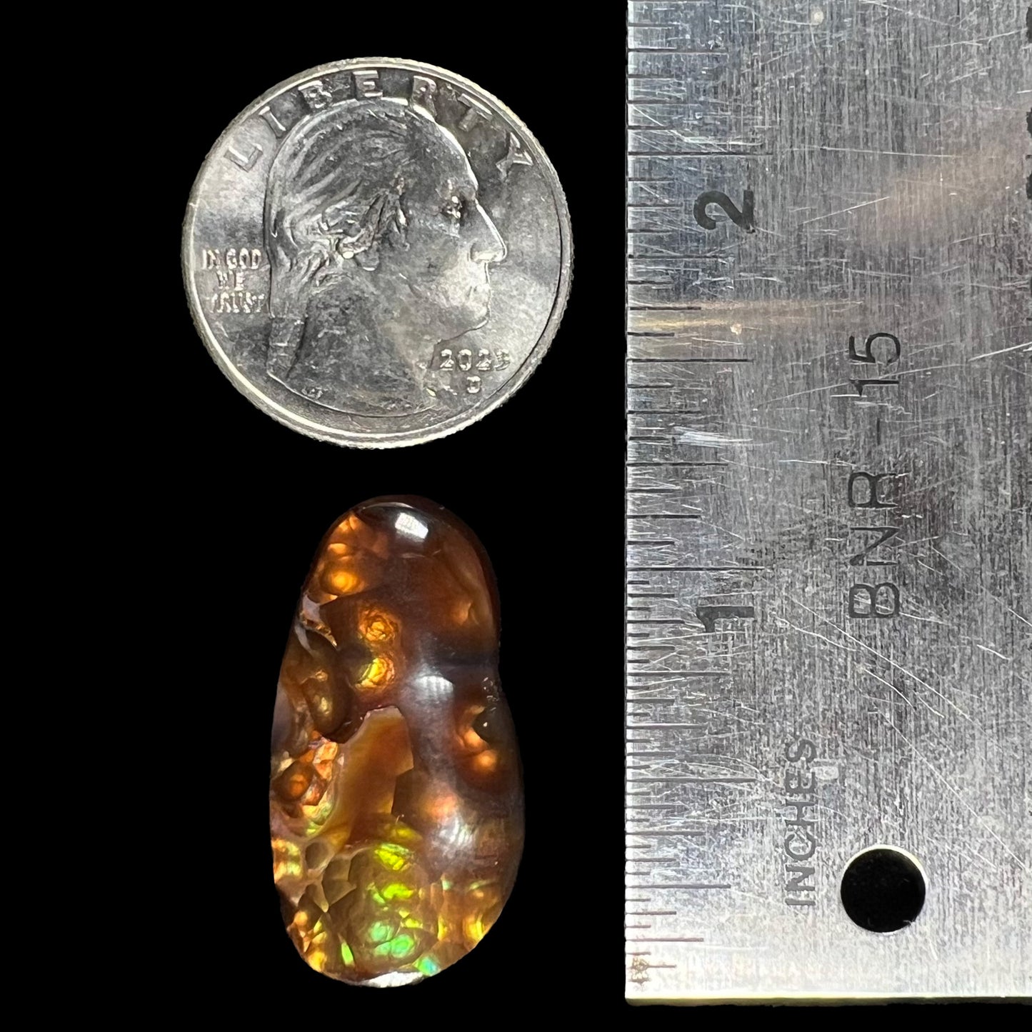 A loose fire agate cabochon.  The stone has iridescent green, yellow, and blue colors.