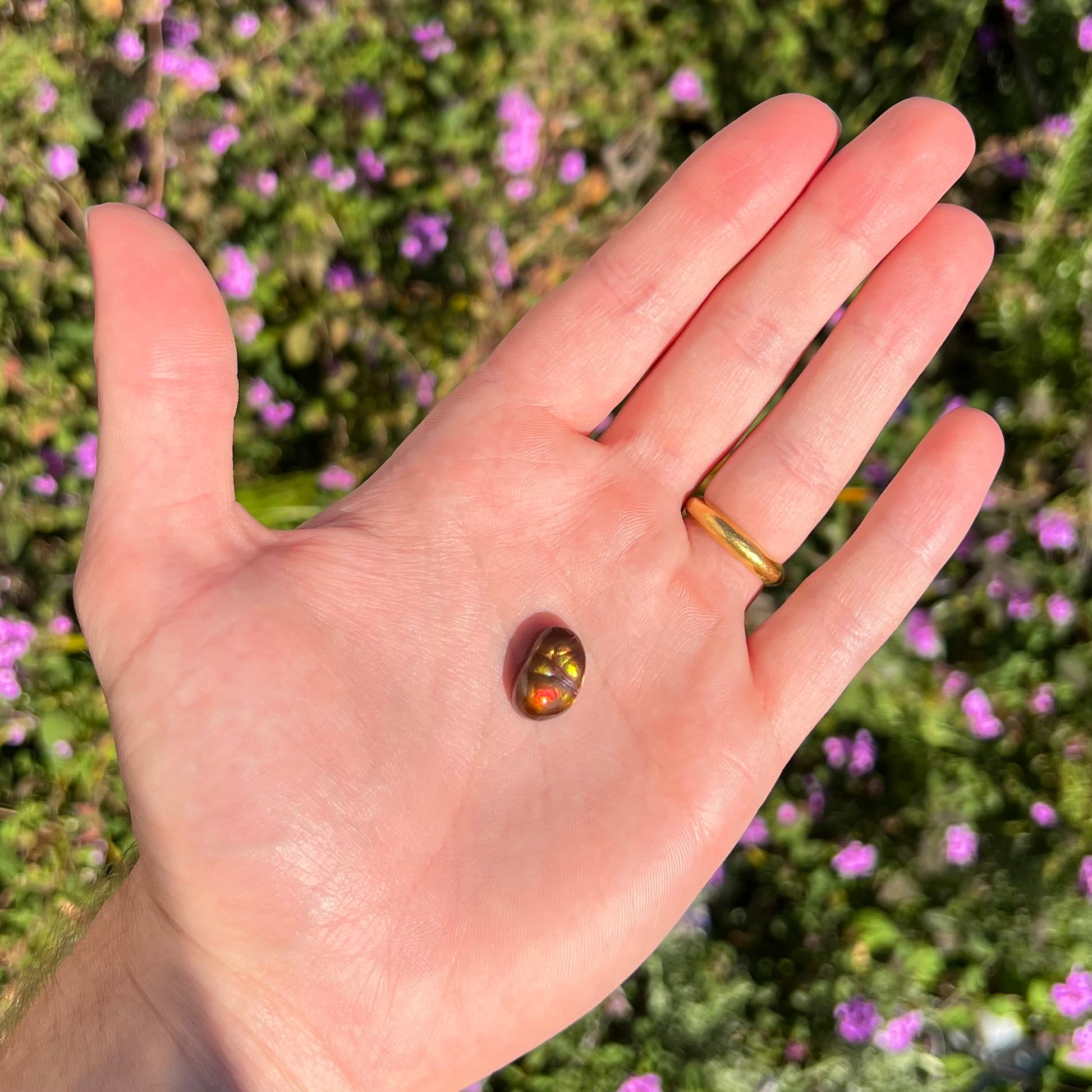 A loose Mexican fire agate cabochon.  The stone has a bright purple and blue iris pattern.