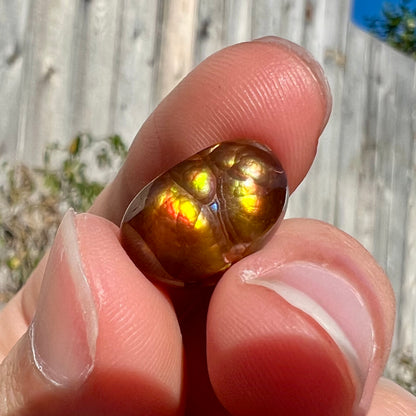 A loose Mexican fire agate cabochon.  The stone has a bright purple and blue iris pattern.