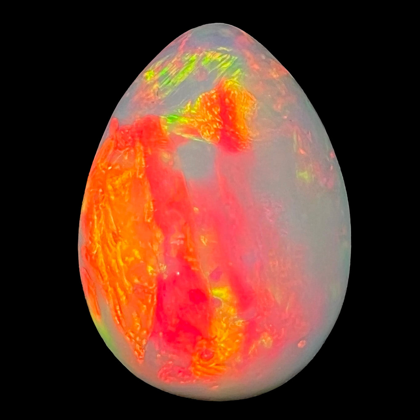 A pear shaped Ethiopian fire opal with vivid red and green play of color.