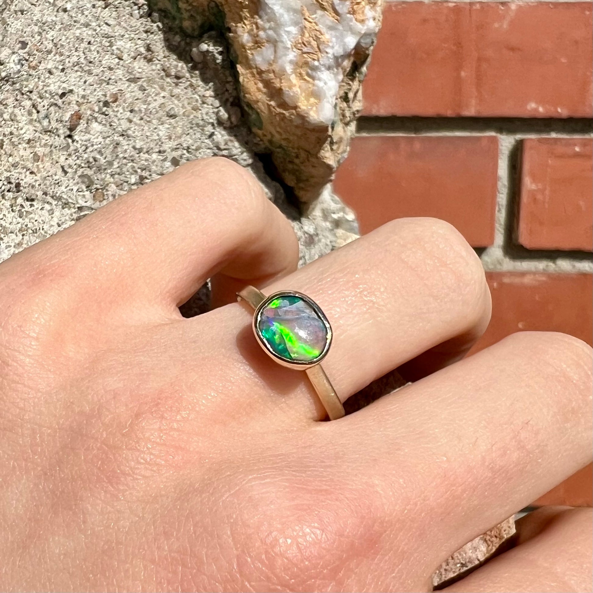 A yellow gold solitaire ring set with a natural Australian cat's eye opal stone.