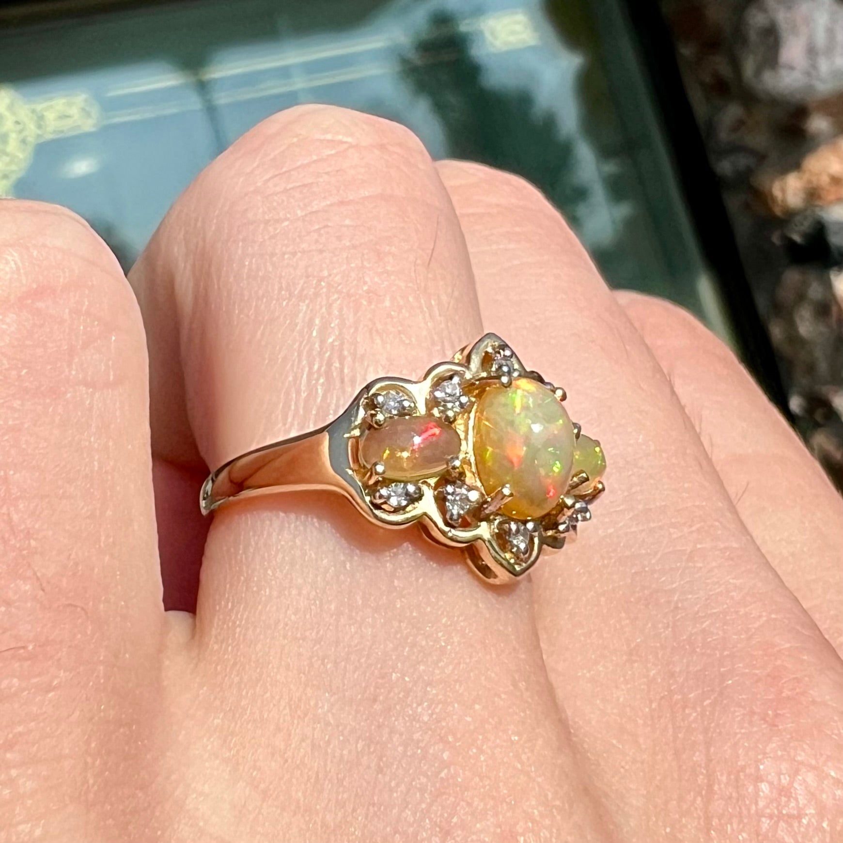 A three-stone gold ring set with Ethiopian fire opals and diamond accents.