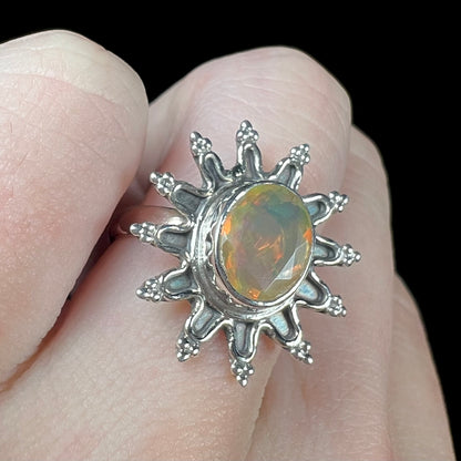 A sterling silver sunburst-style ring mounted with a faceted oval cut Ethiopian fire opal.