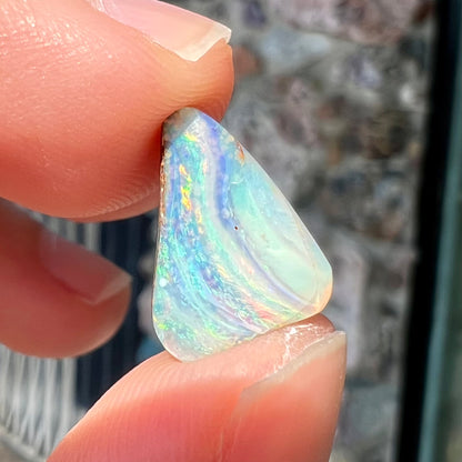 A loose, freeform boulder opal stone from Quilpie, Australia.  The opal has a fissure inclusion.