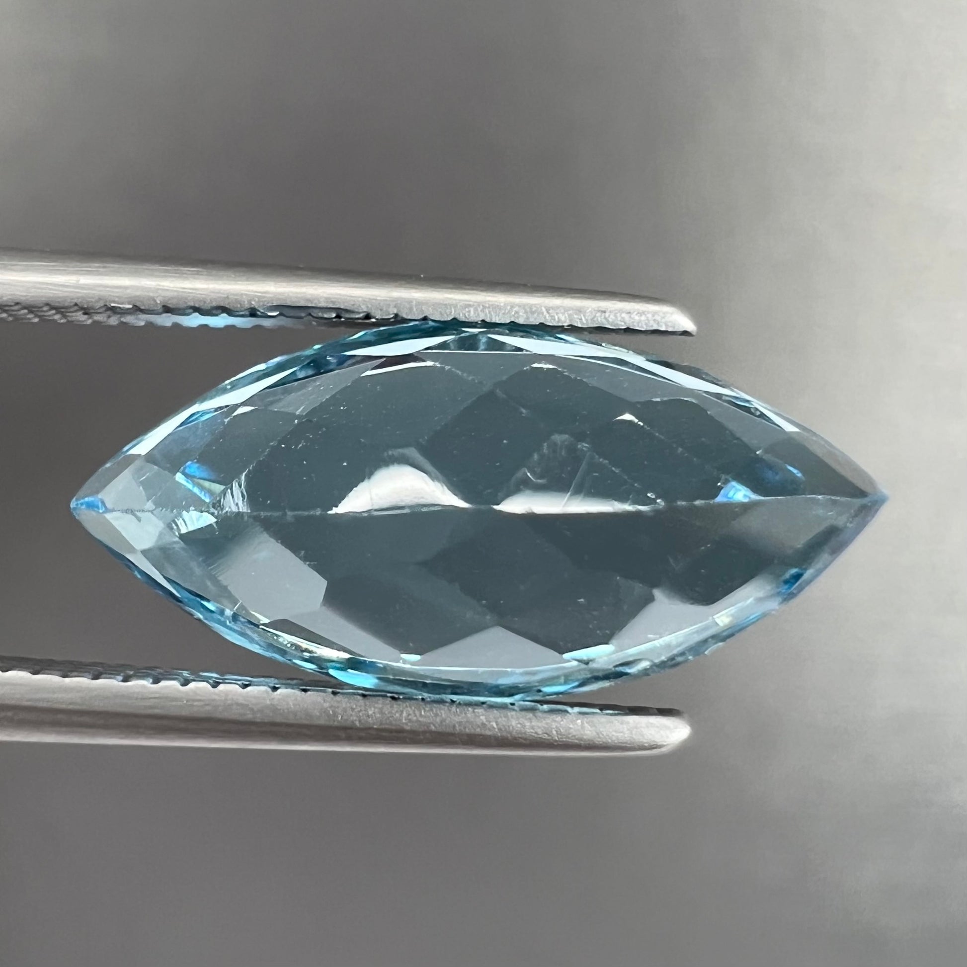 A loose, marquise cut blue topaz gemstone.