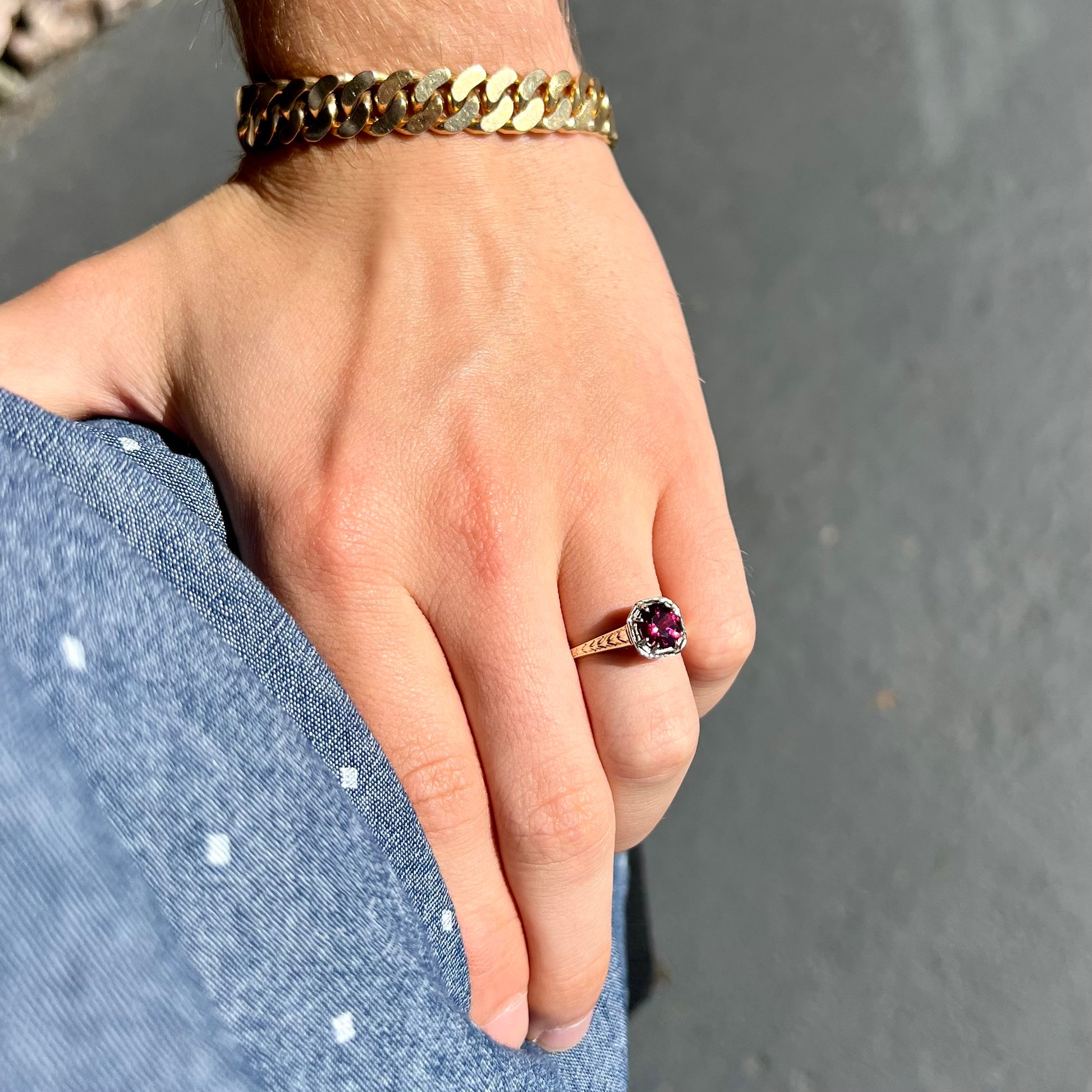 A ladies' yellow gold Art Deco style solitaire ring set with a purple rhodolite garnet gemstone.