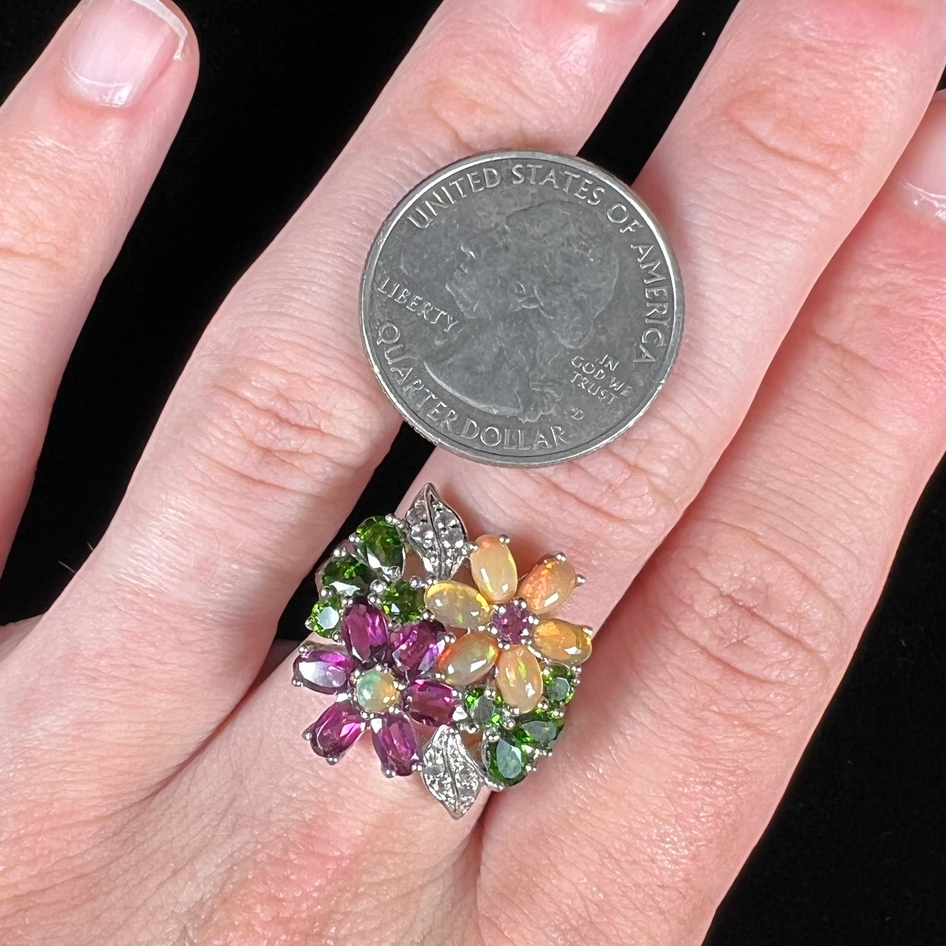 A ladies' gemstone flower design cluster ring set with Ethiopian fire opals, chrome diopsides, rhodolite garnets, and white topaz stones.