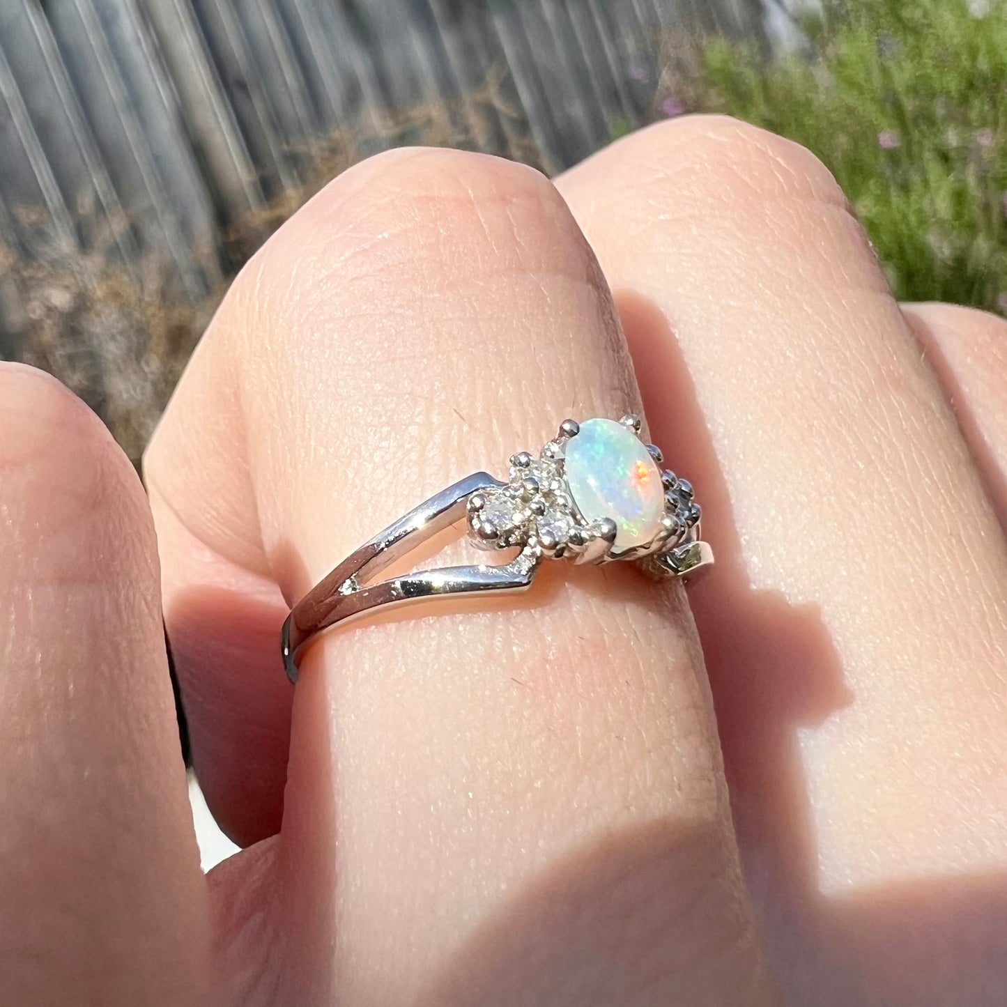 A ladies' white gold opal ring mounted with round diamond accents.