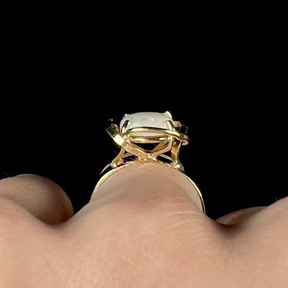 A yellow gold solitaire ring mounted with an oval cut Australian white opal.