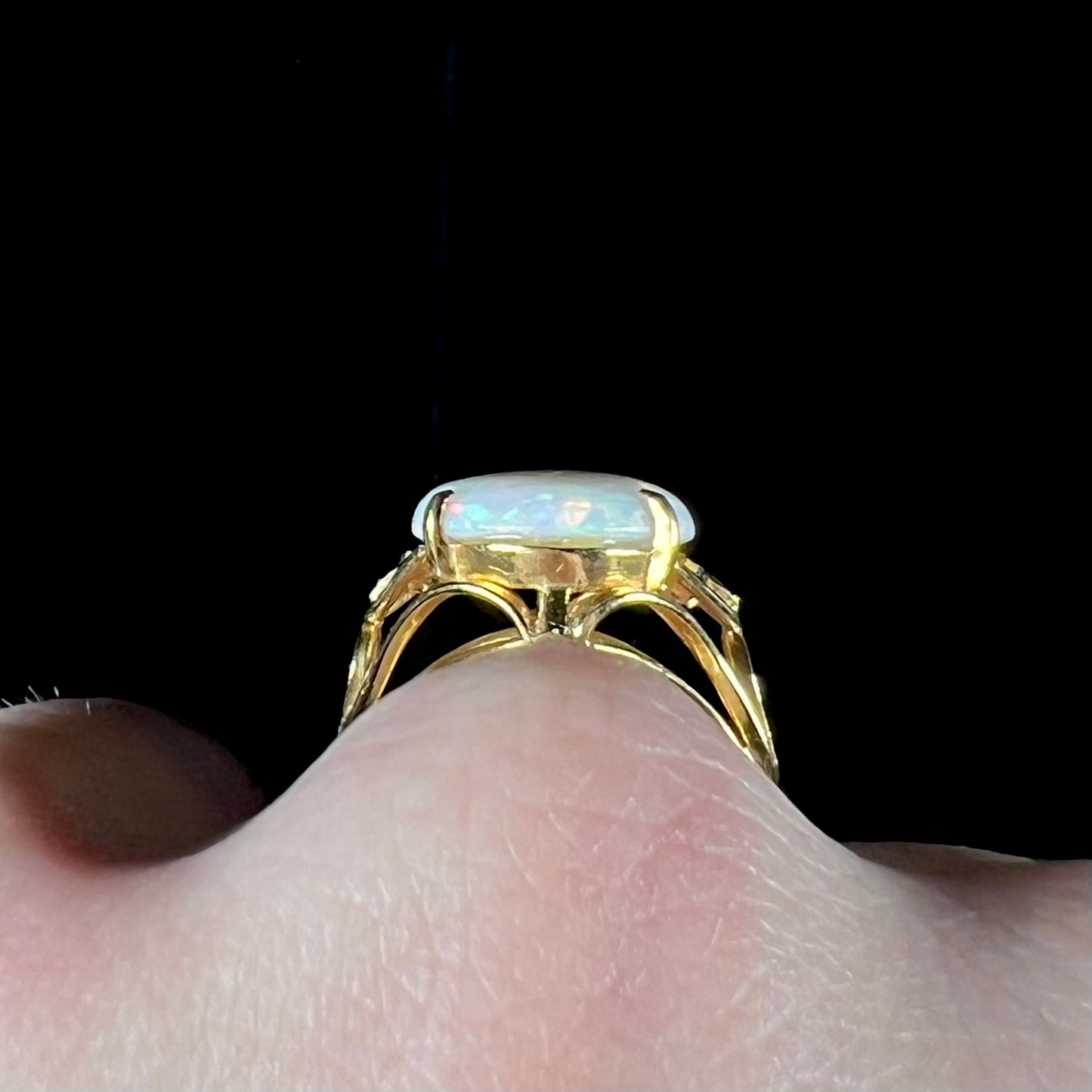 A yellow gold solitaire cocktail ring mounted with a natural white opal from Coober Pedy, Australia.