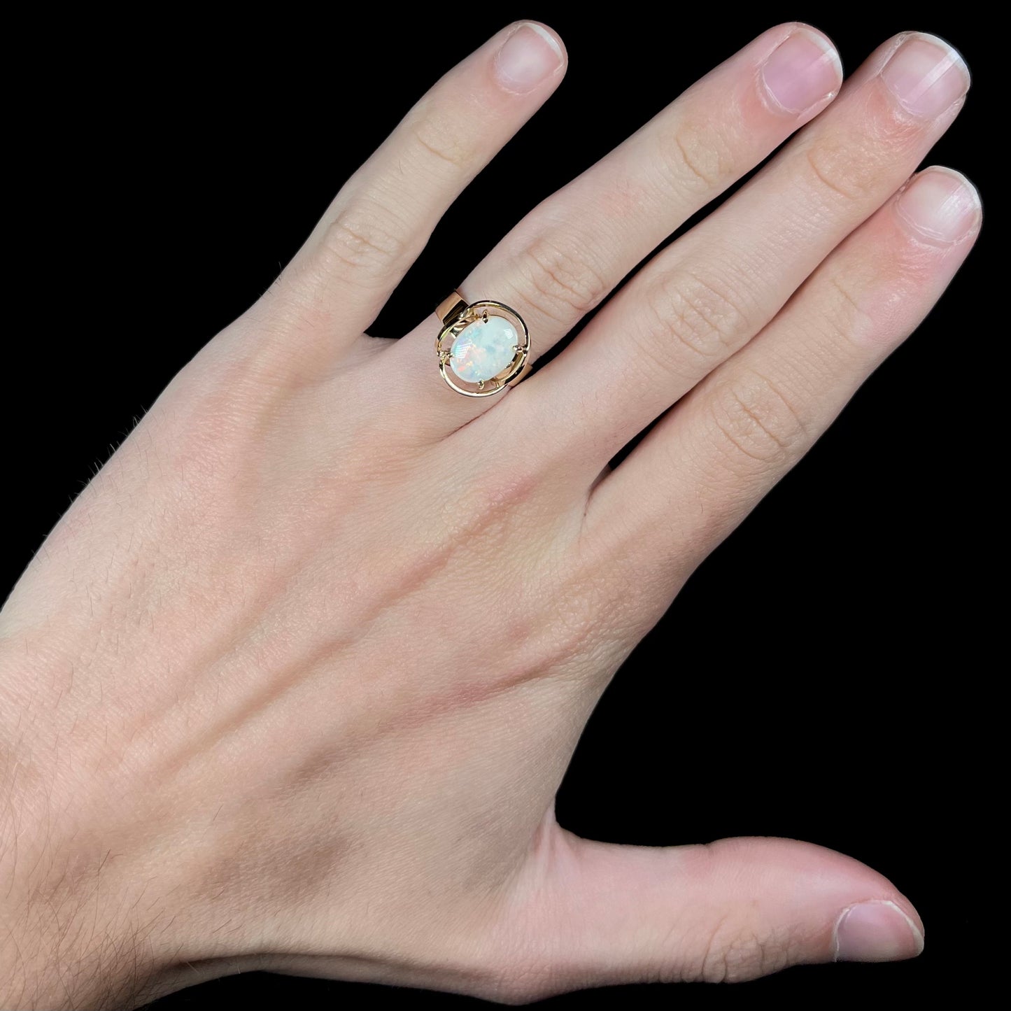 A yellow gold solitaire ring mounted with an oval cut Australian white opal.