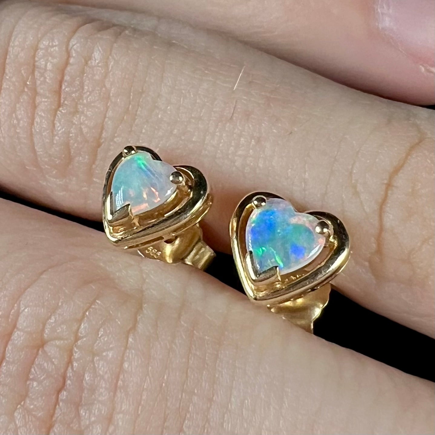 A pair of yellow gold stud earrings mounted with heart shaped natural crystal opals.