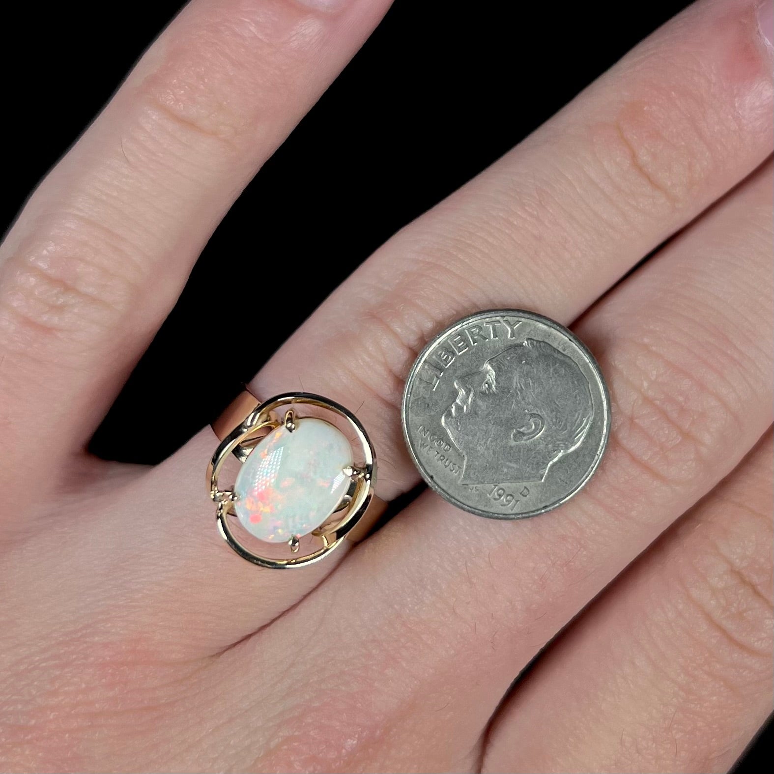 A yellow gold solitaire ring mounted with an oval cut Australian white opal.