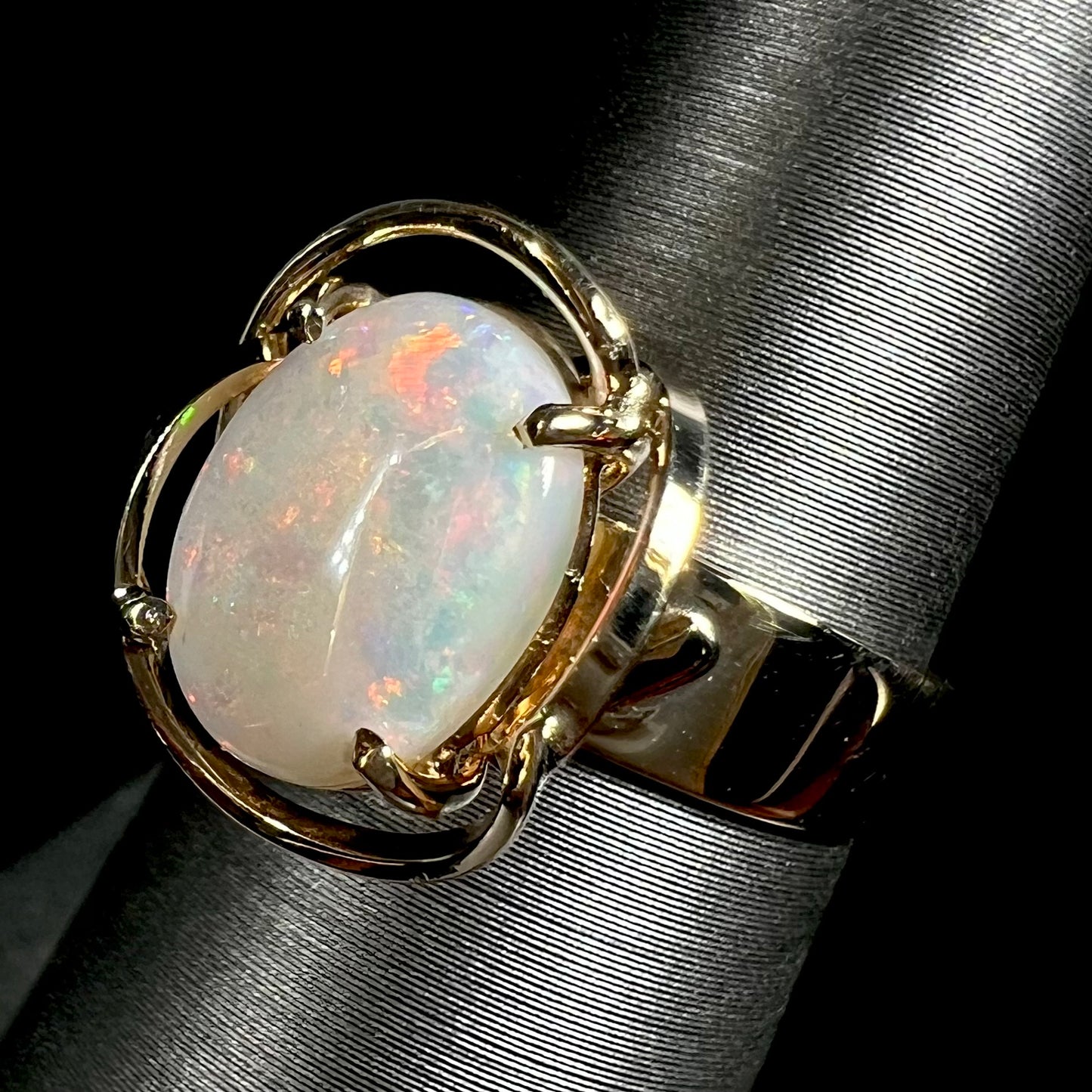 A yellow gold solitaire ring mounted with an oval cut Australian white opal.