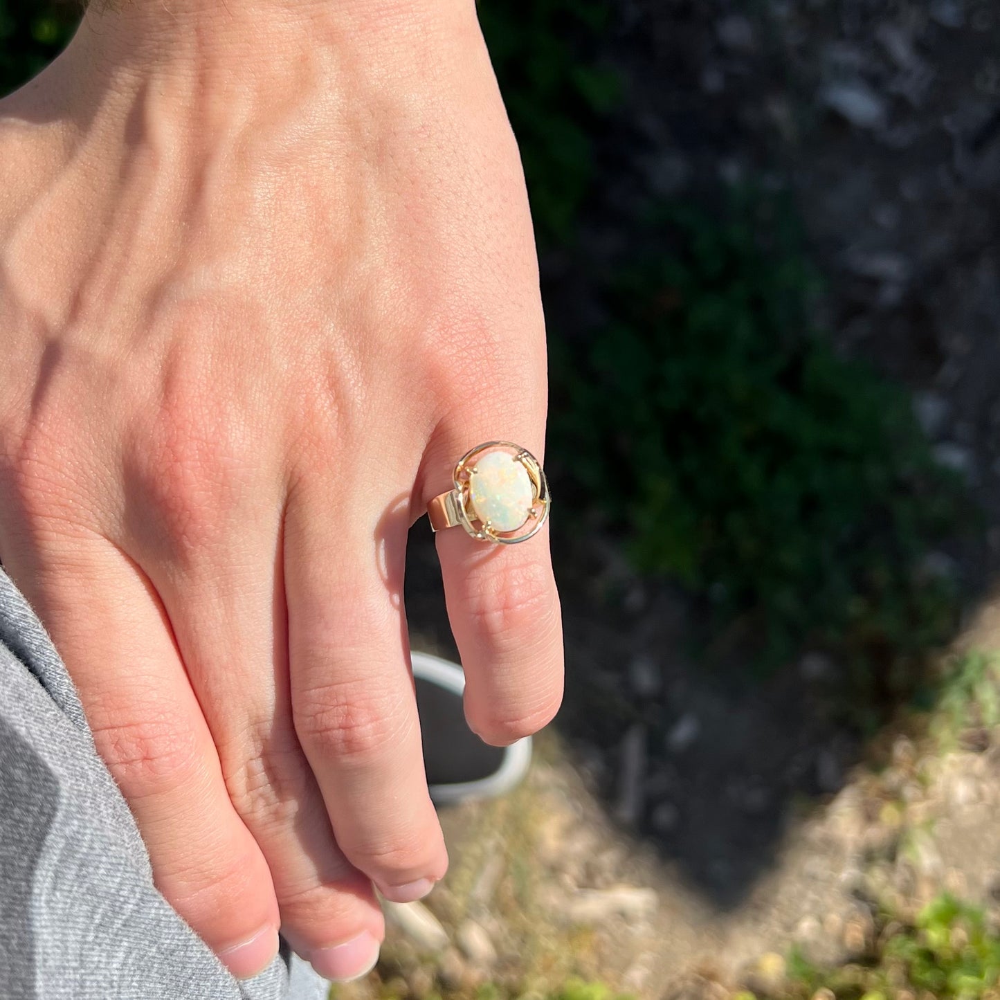 A yellow gold solitaire ring mounted with an oval cut Australian white opal.