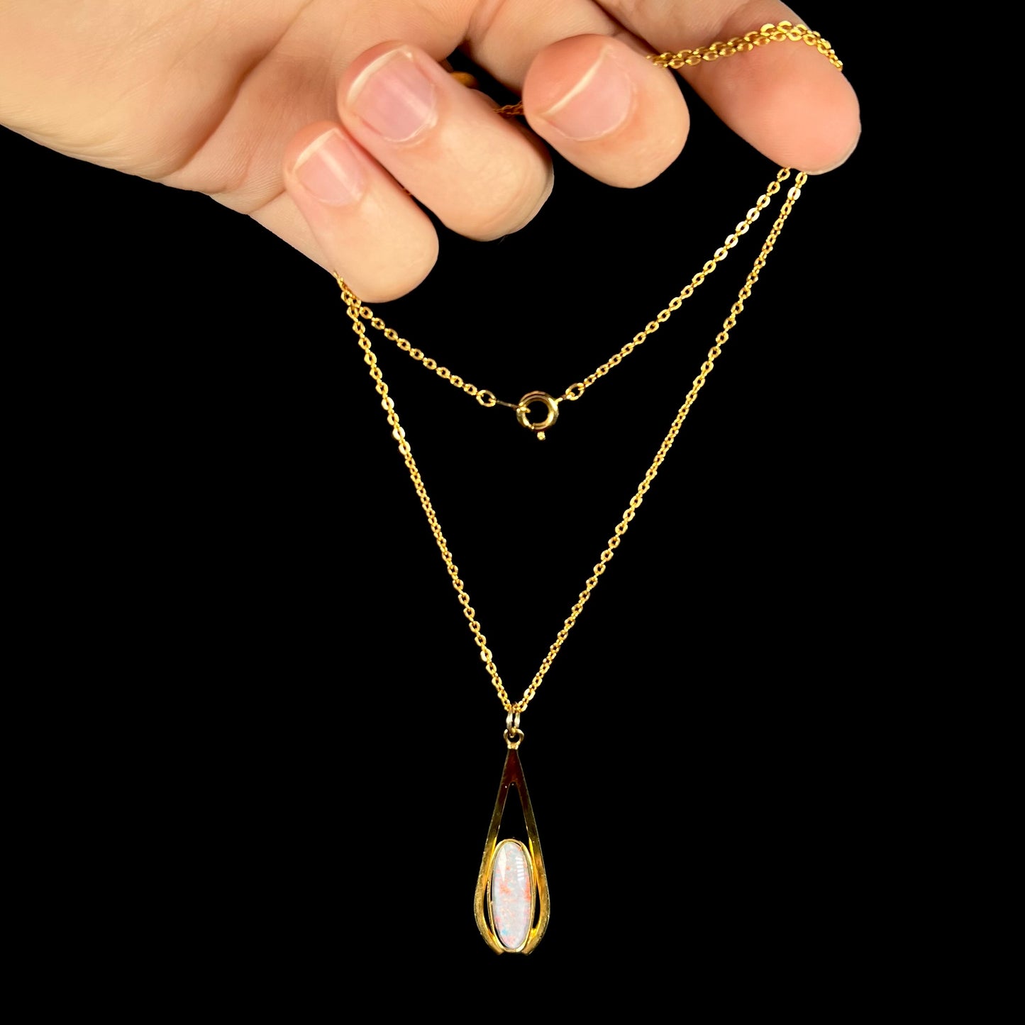 A yellow gold plated necklace set with an oval cut opal triplet.