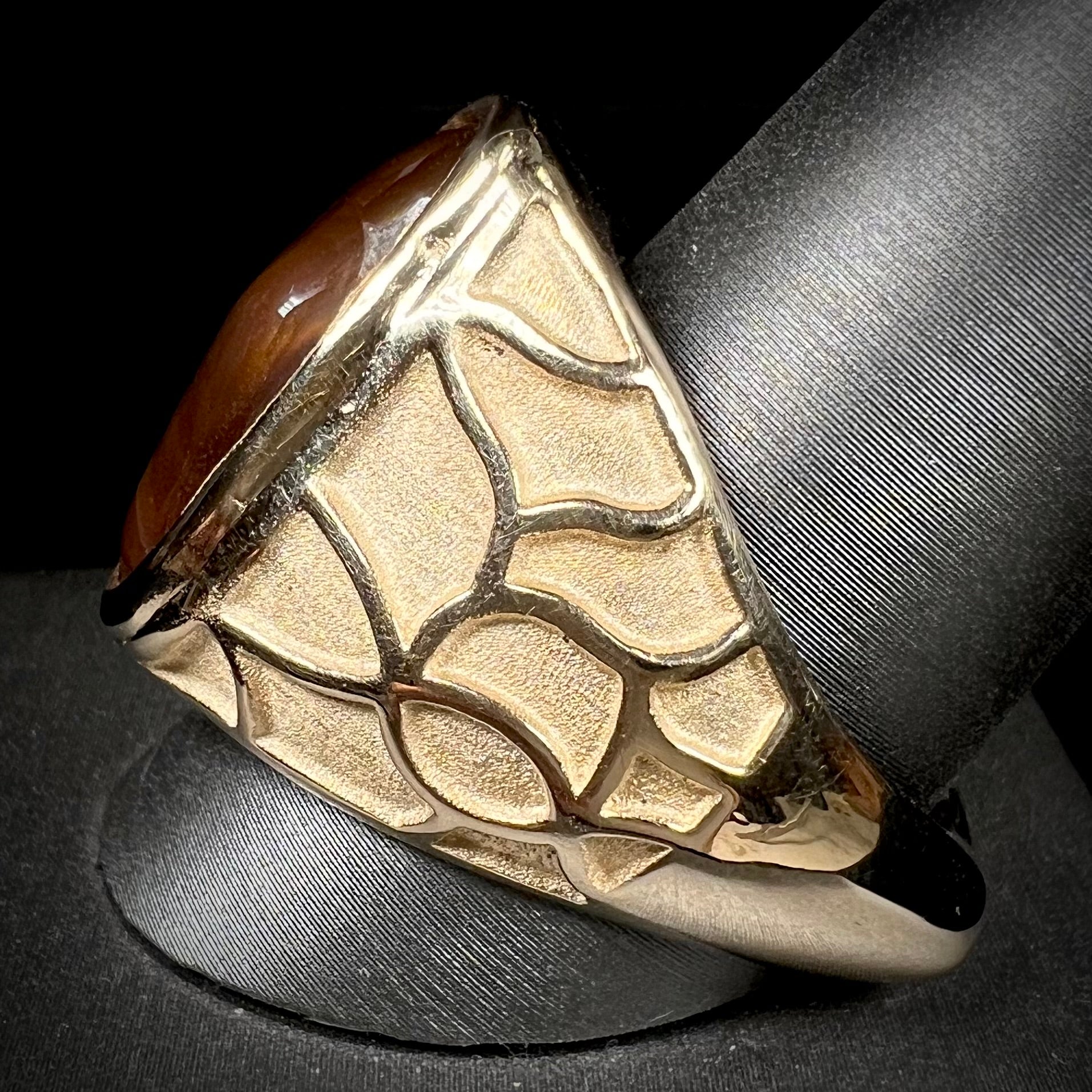 A men's heavy yellow gold ring mounted with a Mexican fire agate stone.  The shank of the ring is textured.