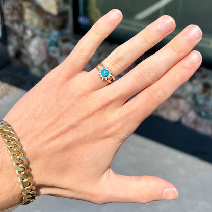 A ladies' round cut black opal and diamond halo ring.  The ring is yellow gold and has a split shank.