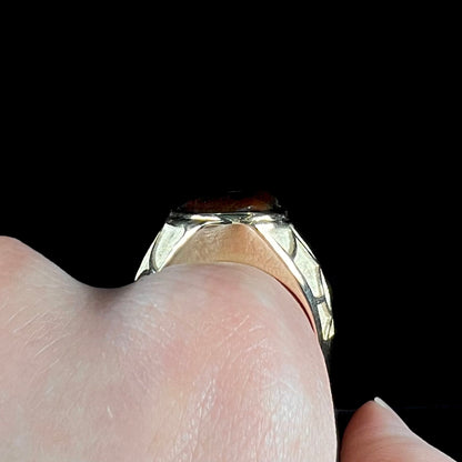 A men's heavy yellow gold ring mounted with a Mexican fire agate stone.  The shank of the ring is textured.