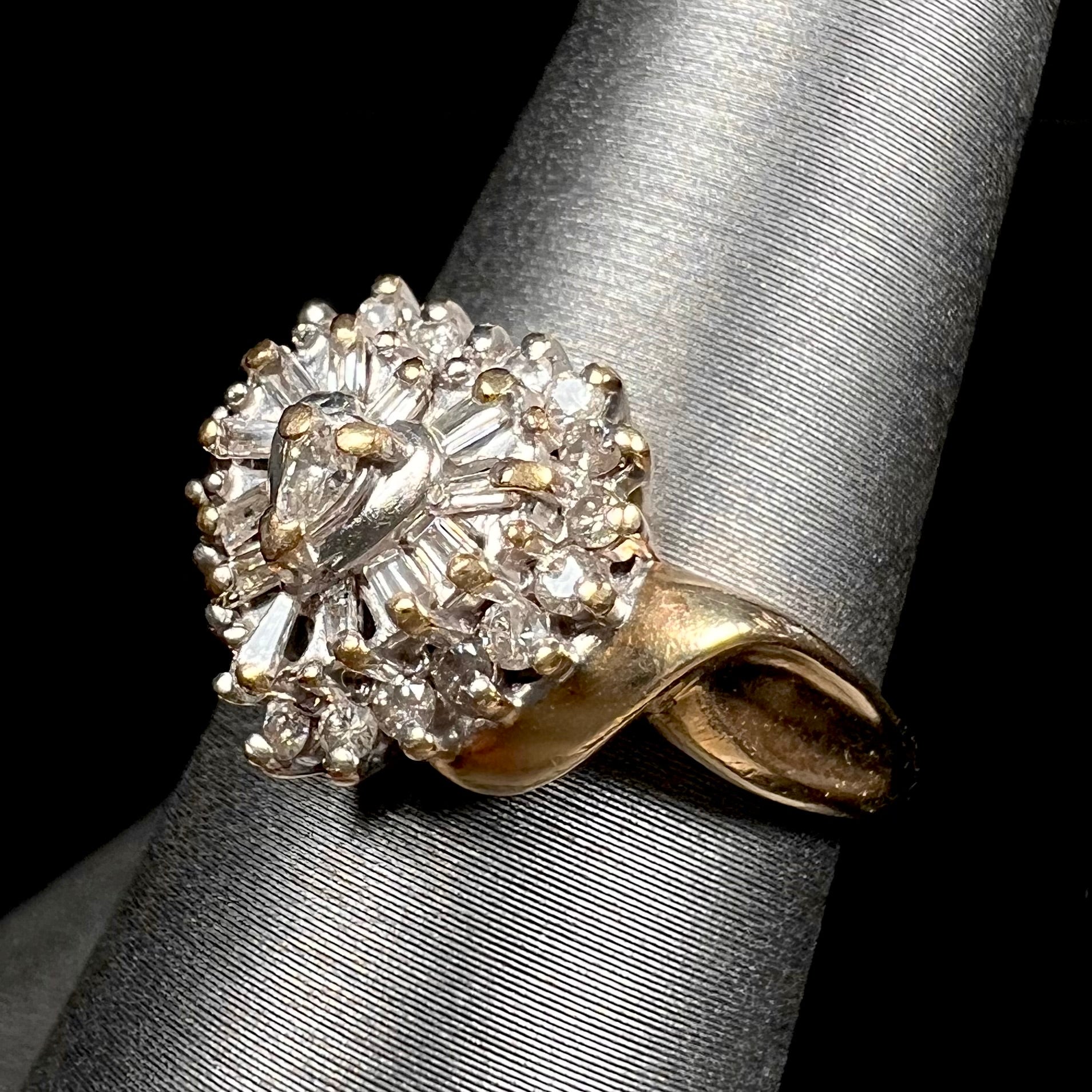 A ladies' heart shaped diamond cluster ring.  The ring is set with pear shaped, baguette cut, and round diamonds.