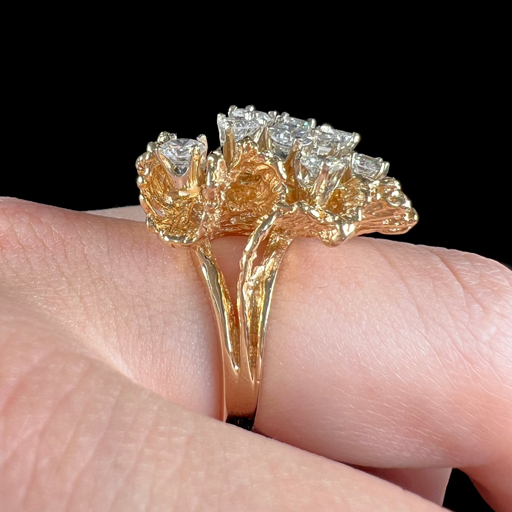 A ladies' 1950's style yellow gold and diamond cluster ring.  The ring is shaped like a leaf with 10 round diamonds set in it.