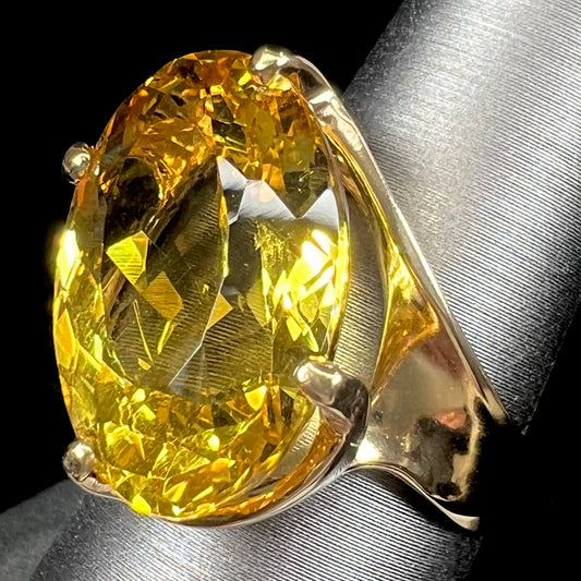 An 18 karat yellow gold solitaire cocktail ring set with a faceted oval cut golden beryl gemstone.