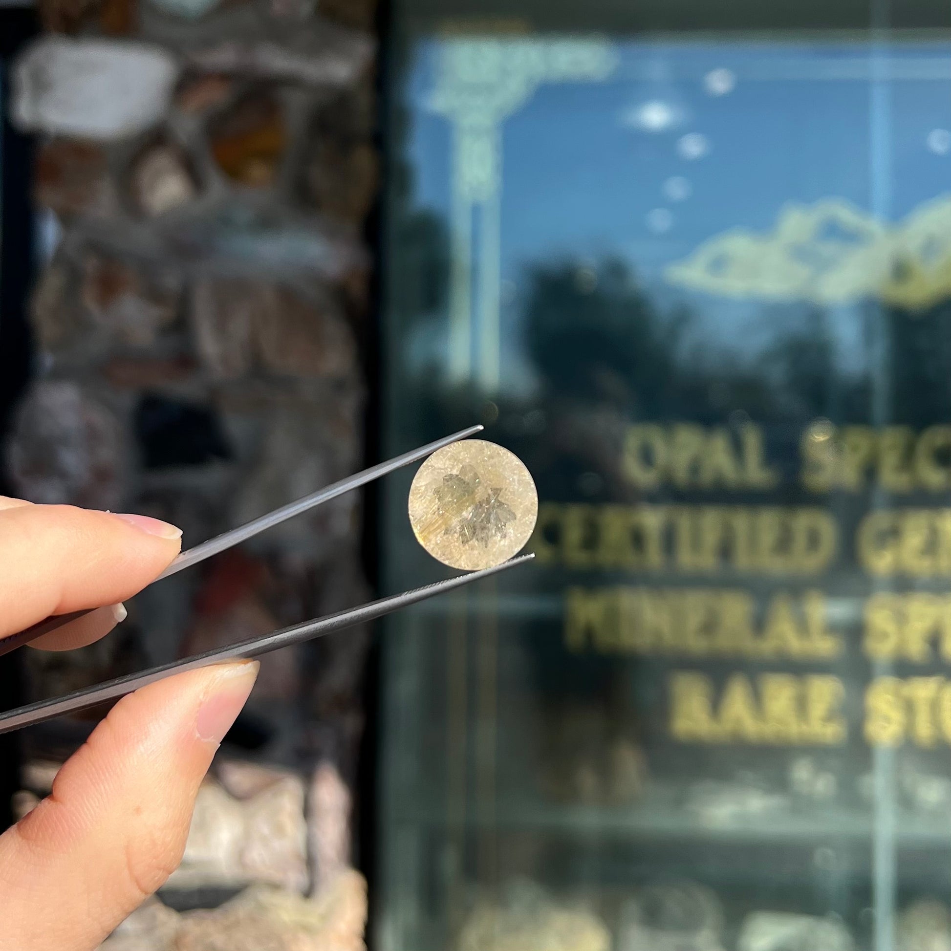 A loose, modified Early American round cut rutilated quartz gemstone.  The rutile inclusions are a golden color.